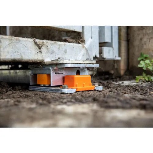 Gallagher wireless cattle scale load bars under a Metal platform with orange wheels on a dirt surface